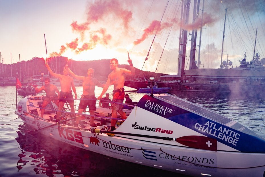 Team Swiss Raw on the boat holding up flares to celebrate their win.